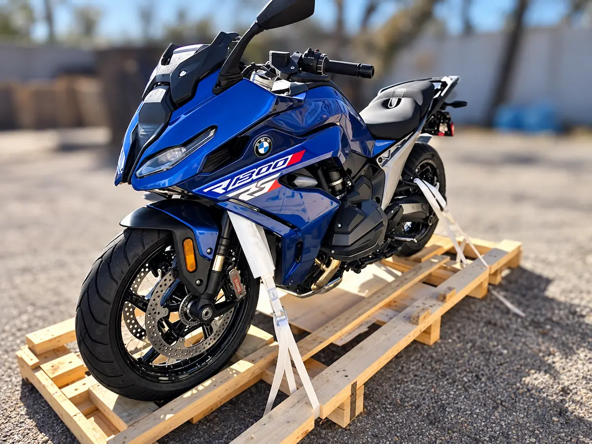 2026 BMW R 1300 RS sport-touring motorcycle finished in Racing Blue Metallic strapped to a wooden shipping crate.